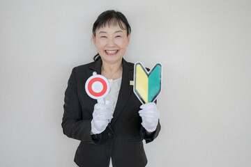 丸を持って手袋をした中高年女性