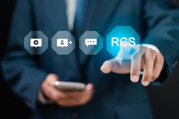 RCS, Rich Communication Services concept. Businessman touching RCS icons on virtual screen.