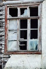 Fototapeta na wymiar The seaside house has long been abandoned. An old ruined window in house on sea of Arctic Ocean