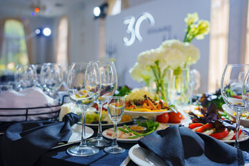 Beautifully set banquet table. Snacks, flowers and wine glasses.