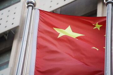 The national flag of China is on the flagpole in front of the building.
