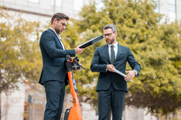 Two business men had a network of business contacts. Businessmen had a solid financial plan. Business man riding an electric scooter on business meeting.