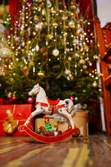 Rocking horse toy on the background of a Christmas tree. 