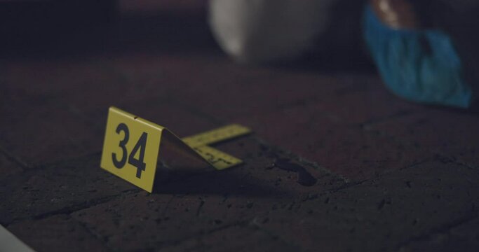 Evidence marker, csi and swab of blood at crime scene with forensic on floor at night for investigation of murder. Professional, expert in gloves and case investigator with observation and search