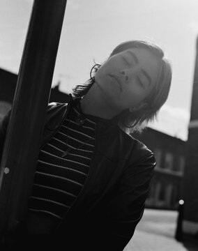 Analog image of young woman posing around a street light.