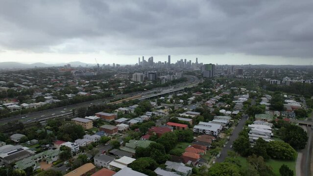 Residential Suburb With Overcast In Queensland, Australia. Brisbane City In Distance. aerial ascending shot