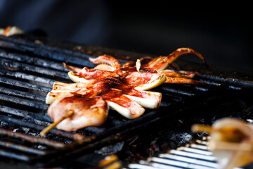  fresh squids is being grilled to a golden perfection on the barbecue grill
