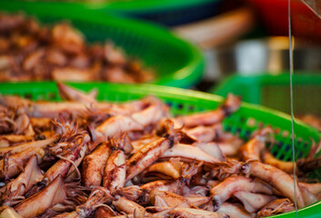green baskets are filled with fresh squids, showcasing a rich ocean flavor