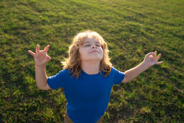 Child breathing fresh air. Kid calmness and relax on nature. Little kid meditates while practicing yoga. Freedom and carefree concept. Outdoors meditating in summer. Beginner meditation.