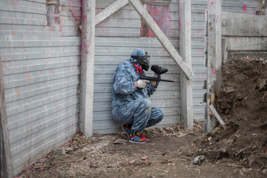 Paintball. Gun and soldier with a sports man playing a military game for fun or training outdoor. War, camouflage and target with a male athlete shooting a weapon outside during an army exercise