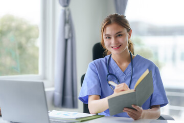 Smiling nurse with stethoscope taking notes in medical office. Healthcare and medical consultation...