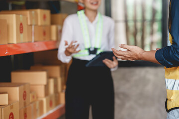 Warehouse staff discussing logistics operations in storage facility. Teamwork and supply chain collaboration concept.