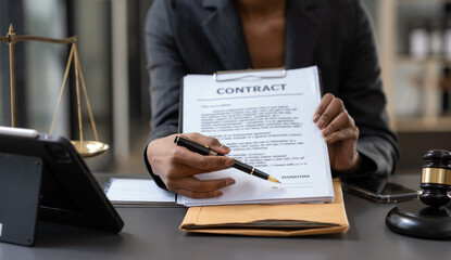 A woman is holding a contract and a pen