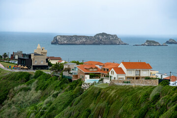 Fototapeta premium Scenic Coastal Town in Cantabria with Houses Overlooking the Sea