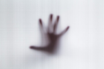 Abstract blur hands silhouettes behind glass foreground. Halloween image concept.