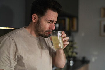Man drinking electrolytes in the kitchen