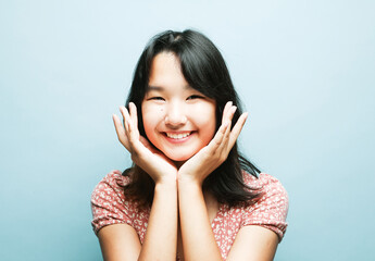 Young asian lady in happiness moment, woman smiling isolated on blue background