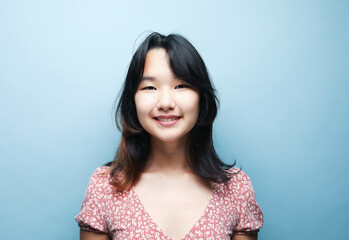 Young asian lady in happiness moment, woman smiling isolated on blue background