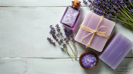 Obraz na płótnie Canvas Two pieces of handmade gift soap in purple and violet color close-up and lavender salt in a bottle lie on a wooden tabletop, next to a bouquet of lavender on a wooden tabletop, copy space