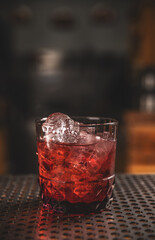 Elegant glass of red cocktail on bar counter