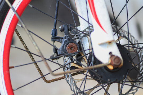 Closeup photo of bicycle rims with some rusted parts.