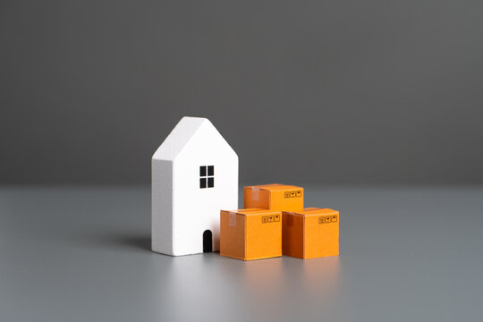 White house and boxes. House moving. Online orders. Home delivery