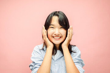 Cheerful Young asian woman amaze with shock deal, isolated on pink background