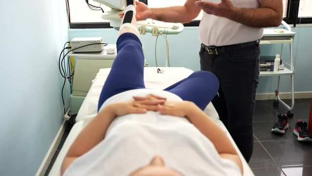 Doctor checking the leg mobility of a patient on the stretcher