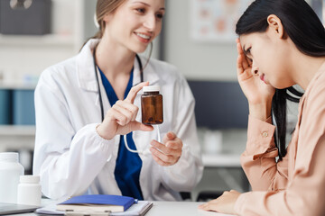 Attractive female Caucasian female doctor and psychologist gives advice, encouragement to female Asian patients. from depression in hospital examination room. cognitive behavioral therapy CBT