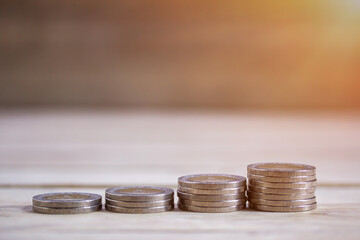 Coin stacks on wood table background.