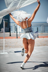 Young sexy girl in space silver micro skirt dancing with white silk scarf waving gracefully, female...