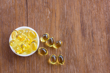 Fototapeta na wymiar Cod liver oil omega 3 gel capsules on wooden background