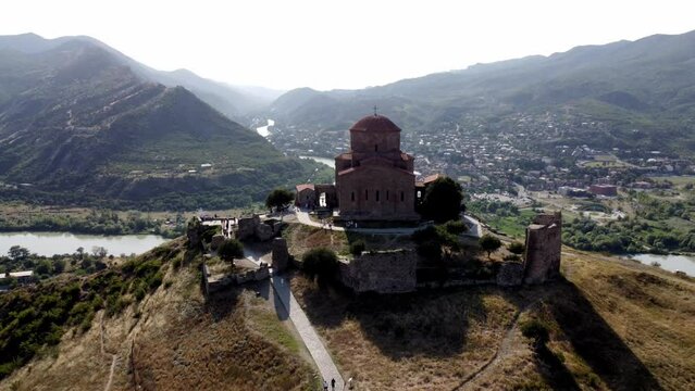 Behold the breathtaking aerial vista of the revered Jvari cliffside Orthodox monastery, nestled amidst the scenic splendor of Mtskheta, Georgia, on a sun-kissed summer day