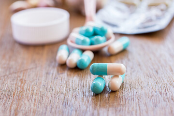 Fototapeta na wymiar Selective focus on pill spread on wooden background.