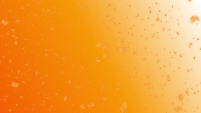 Orange colored autumn leaves flowing in the wind on sunset sky orange background. Abstract background with a scene of autumn and early winter time.