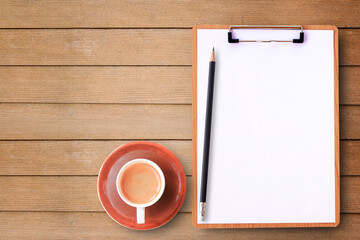 Top view with medical clipboard,pencil and cup of coffee on wood table background.