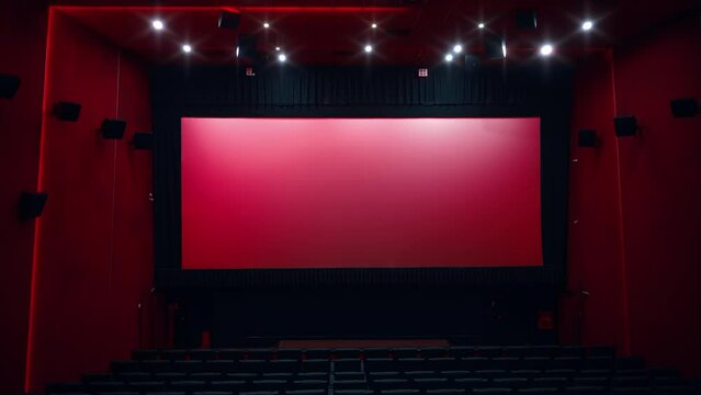 Large empty movie theater auditorium with illumination and blank screen