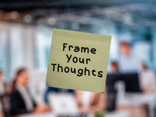 Post note on glass with 'Frame Your Thoughts'.