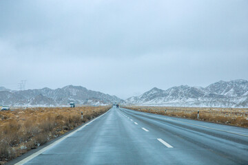 Hainan Mongolian and Tibetan Autonomous Prefecture, Qinghai Province-Grasslands and roads under the snow-capped mountains
