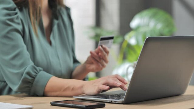shopping online close up on woman hand typing at computer laptop using credit card to purchase pay on internet website store,e-commerce payment transaction concept