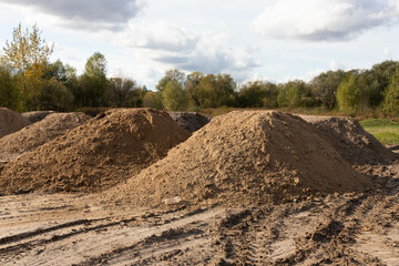 Mountain of sand at a construction site. Foundation material. Soil prepared to strengthen the soil....