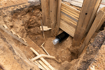 Arranged PVC of water pipes are assembled and placed in trench on building site.