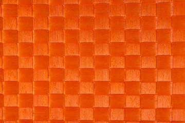 Orange background, texture of weaving strips in the form of squares.