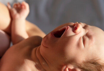 A newborn boy is crying. The newborn baby is tired and hungry. The children are crying. Babies scream.Selective focus