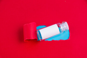An ampoule of the COVID-19 coronavirus vaccine is a gift on a red background.