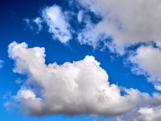 Obraz premium White fluffy clouds in the deep blue sky. Heaven background