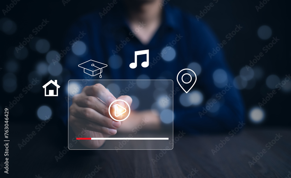 Poster a person is pointing at a screen with a video playing. the screen is lit up and has a blue backgroun