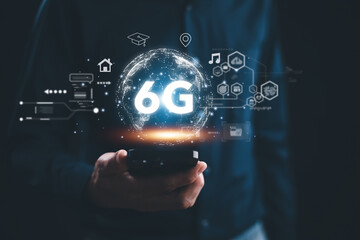 A person is holding a cell phone with the word 6G on it. The image is a representation of the future of technology and the advancements that will be made in the field of telecommunications - obrazy, fototapety, plakaty