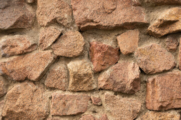 Grunge texture stone wall background. Rough old stone or rock texture of mountains. Coarse facing, grungy aged stonework city. Front antique decor house. General layout of stone masonry.