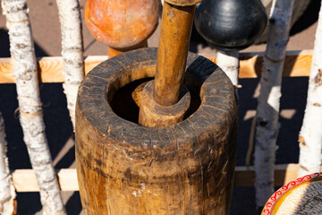 An old authentic wooden mortar with a wooden pestle in it, a mill.